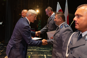 Na zdjeciu Burmistrz Miasta Czeladź wręcza wyróżnionym policjantom listy gratulacyjne na scenie.