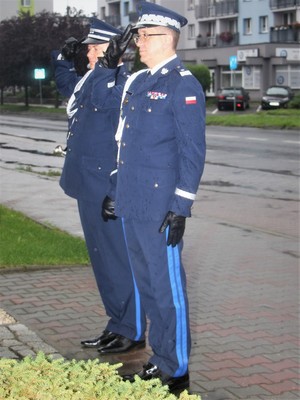 Komendant Wojewódzki Policji w Katowicach oraz Komendant Powiatowy Policji w Będzinie salutują przed pomnikiem.