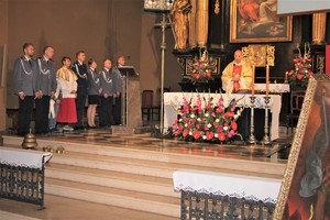 Zdjęcie, na którym widzimy policjantów tworzących asystę liturgiczną w kościele oraz przy ołtarzu znajduje się Biskup Sosnowiecki prowadzący Mszę Świętą.