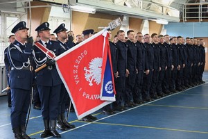 Zdjęcie. Widoczni stojący na sali sportowej umundurowani policjanci