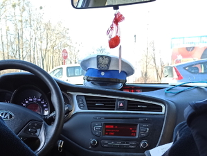 Na zdjęciu czapka policjanta z ruchu drogowego położona na środku deski rozdzielczej.