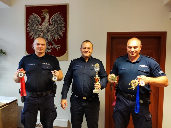 Zdjęcie przedstawia Komendanta Powiatowego Policji w Będzinie oraz dwóch policjantów, którzy zdobyli złote medale na Mistrzostwach Świata w uginaniu ramion ze sztangą.
