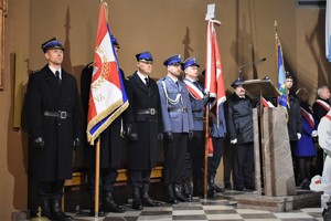 Zdjęcie grupowe, na którym w kościele znajdują sztandary, w tym sztandar Komendy Powiatowej Policji w Będzinie.