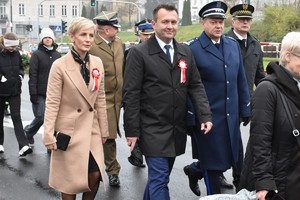 Zdjęcie grupowe, na którym widzimy przemarsz przedstawicieli służb mundurowych u boku Starosty Będzińskiego i jego żony.