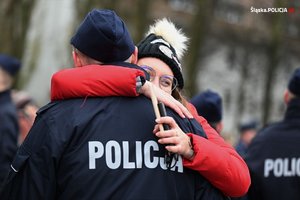 Na zdjęciu kobieta przytula policjanta.