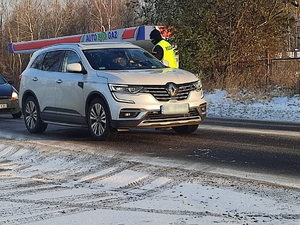 Zdjęcie-umundurowany policjant zatrzymuje pojazd do kontroli i bada trzeźwość kierowcy.