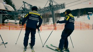 Na zdjęciu dwóch policjantów w kombinezonach narciarskich na stoku.