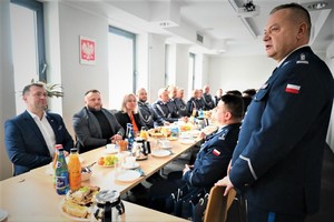 Na zdjęciu Komendant Powiatowy Policji w Będzinie przemawia do grupy osób podczas pożegnania komendantów.