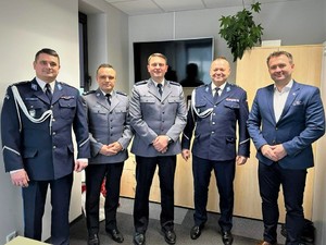 Na zdjęciu Policjanci w umundurowaniu galowym oraz mężczyzna w garniturze, zdjęcie grupowe.