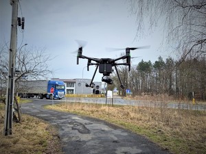 Na zdjęciu dron wznoszący się do góry przy drodze.