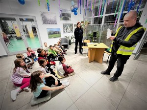 Na zdjęciu technik kryminalistyki wraz z policjantką występują przed dziećmi.