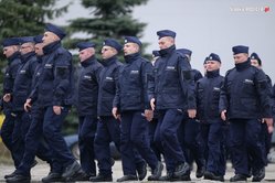 Zdjęcie, na którym umundurowani policjanci maszerują w szyku