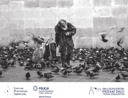 Czarno-białe zdjęcie przedstawiające osobę bezdomną karmiącą gołębie