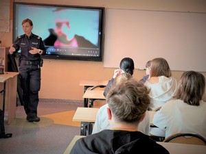 Na zdjęciu policjantka wypowiada się przed uczniami w klasie.