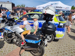 Na zdjęciu dwóch chłopców siedzi na motocyklu policyjnym.