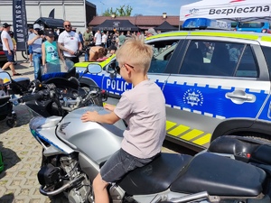 Na zdjęciu chłopiec siedzi na motocyklu policyjnym.