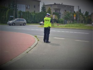 Na zdjęciu policjant stoi z urządzeniem mierzącym prędkość.