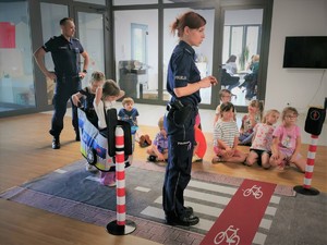 Na zdjęciu policjant i policjantka przemawiają do dzieci.