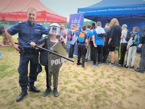 Na zdjęciu policjant z dzieckiem przebranym za policjanta pozują.