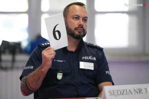 Policjant trzyma tabliczkę z numerem 6