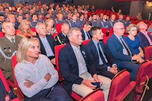 Zdjęcie grupowe zaproszonych gości i policjantów siedzących w teatrze.