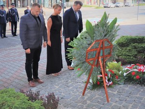 Na zdjęciu samorządowcy przy złożeniu kwiatów przy tablicy pamiątkowej.