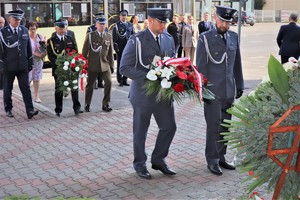 Na zdjęciu funkcjonariusze służby więziennej składający kwiaty pod obeliskiem.