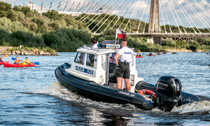 Na zdjęciu policjant płynący na motorówce.