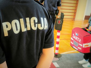 Na zdjęciu napis POLICJA na koszulce oraz autochodzik straży pożarnej