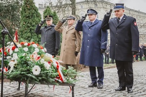 Na zdjęciu przedstawiciele służb mundurowych podczas złożenia kwiatów pod pomnikiem oddają honory.