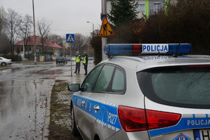 Na zdjęciu radiowóz stojący na ulicy podczas pory deszczowej.