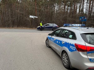 Na zdjęciu widoczny policyjny radiowóz oraz badający trzeźwość policjant.