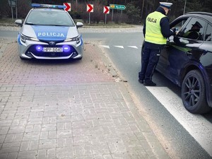 Na zdjęciu policjant kontrolujący trzeźwość na drodze.