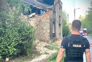 Na zdjęciu policjant stoi przed budynkiem, w którym doszło do wybuchu.