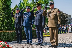 Na zdjęciu Komendant Powiatowy Policji oraz komendanci i szefowie innych służb salutują po wręczeniu kwiatów.