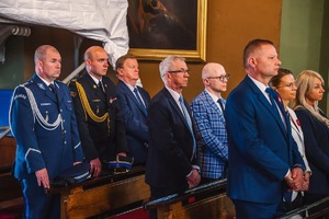 Zdjęcie grupowe stojących osób w kościele, wśród których znajduje się Komendant Powiatowy Policji w Będzinie.
