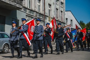 Na zdjęciu widzimy policjantów w poczcie sztandarowym podczas przemarszu ulicami miasta.