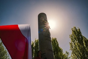 Zdjęcie przedstawia flagę biało czerwoną oraz pomnik.