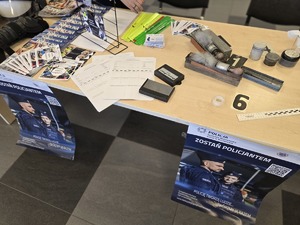 Na stole rozłożone materiały promocyjne Policję.