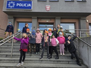 Zdjęcie grupowe harcerzy oraz policjantki przed komendą.