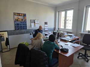Na zdjęciu policjant z kadr przyjmuje dokumenty od zainteresowanych pracą w Policji kobiet