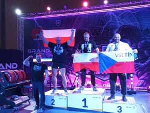Na zdjęciu dwóch braci na podium z medalami trzymają flagi Polski.