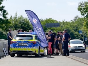 Na zdjęciu radiowóz policyjny i zgromadzeni ludzie.