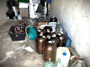 Na zdjęciu w pomieszczeniu różne butelki, kanistry i inne przedmioty do przechowywania cieszy.