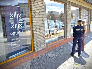 Na zdjęciu policjantka i kobieta przy wystawie ustawionej na dworcu PKP.