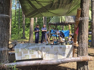 Na zdjęciu widzimy policjantkę i policjanta, którzy rozmawiają z uczestniczkami obozu.