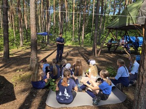 Na zdjęciu widzimy policjantkę i policjanta, którzy rozmawiają z uczestniczkami obozu.