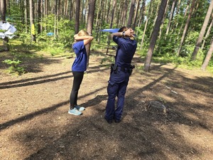 Na zdjęciu policjantka i dziewczyna trzymają się za szyje chroniąc głowę.