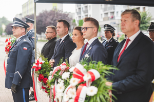 Na zdjęciu grupa gości z kwiatami podczas uroczystości przed będzińską komendą.