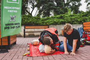 Na zdjęciu ratownik medyczny uczy chłopca jak udzielać pierwszą pomoc.
